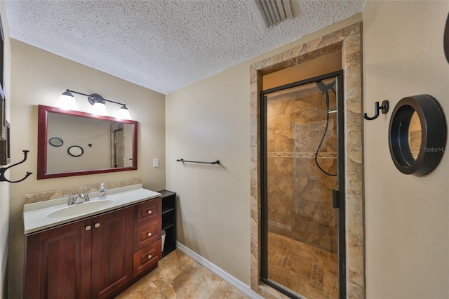 bathroom featuring an enclosed shower, vanity, and a textured ceiling