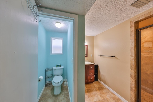 bathroom featuring a shower with shower door, tile patterned flooring, vanity, toilet, and a textured ceiling