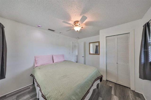 bedroom with ceiling fan, dark hardwood / wood-style flooring, a closet, and a textured ceiling