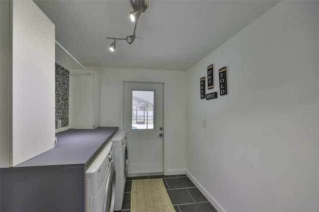 interior space featuring washer / dryer, track lighting, and dark tile patterned flooring