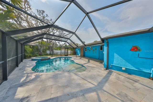 view of pool featuring an in ground hot tub, a patio, and glass enclosure