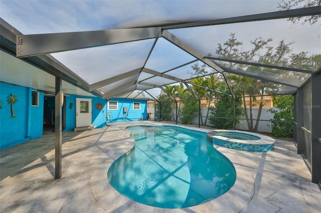 view of pool with an in ground hot tub, a lanai, and a patio