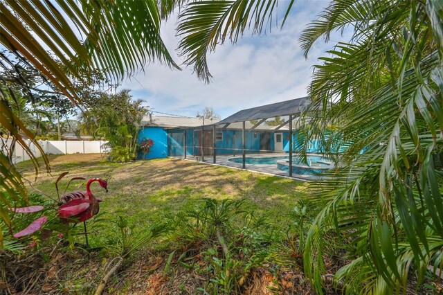 view of yard featuring a fenced in pool and a lanai