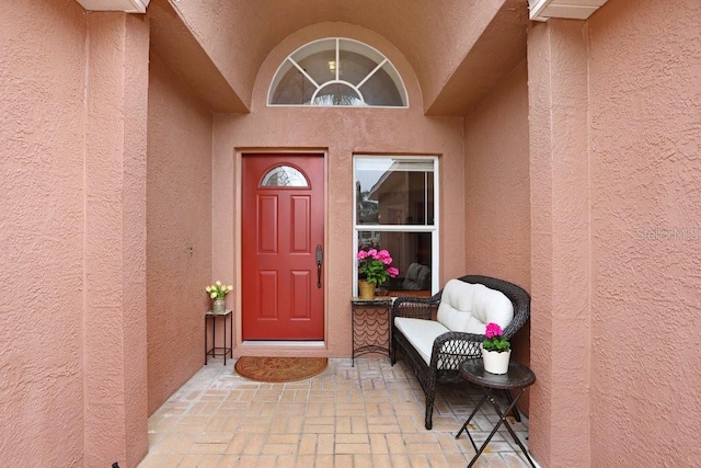 doorway to property featuring stucco siding