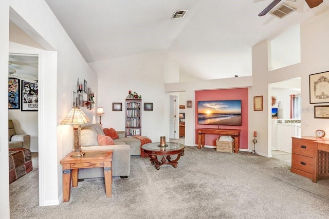 carpeted living area featuring lofted ceiling, ceiling fan, visible vents, and baseboards