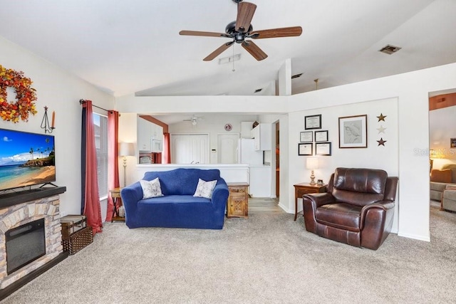 living area with carpet floors, a fireplace, visible vents, a ceiling fan, and vaulted ceiling