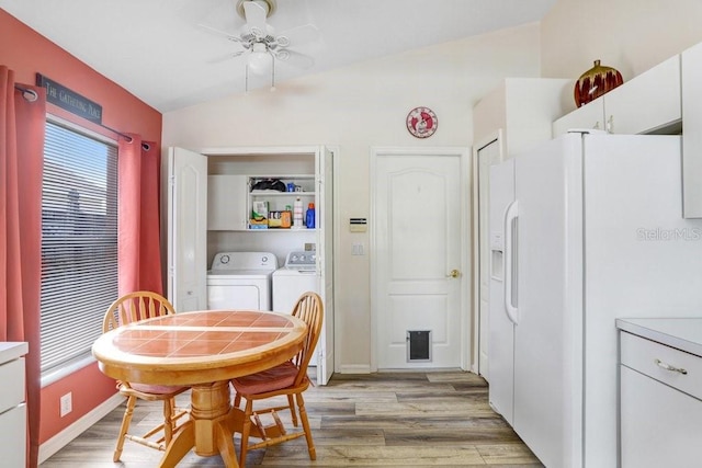 dining room featuring light wood-style floors, lofted ceiling, ceiling fan, and washer and clothes dryer