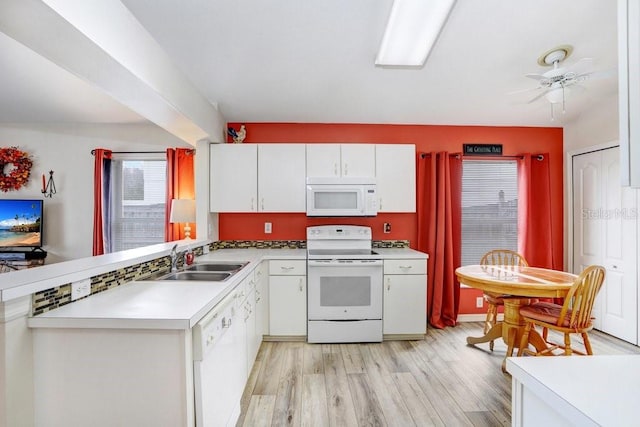 kitchen with light wood-style flooring, white appliances, a sink, white cabinets, and light countertops