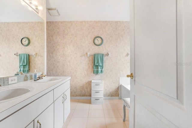 bathroom with wallpapered walls, tile patterned flooring, visible vents, and a sink