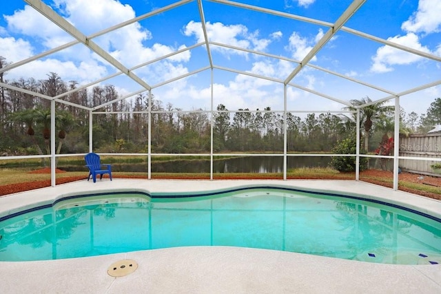 outdoor pool with a patio area, glass enclosure, and a water view