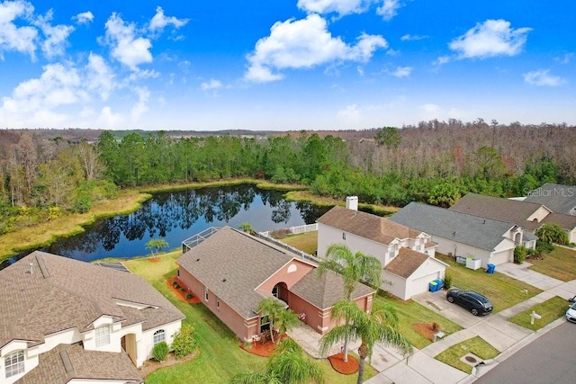 birds eye view of property featuring a water view and a view of trees