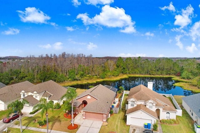 drone / aerial view with a water view and a forest view