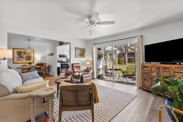 living room featuring ceiling fan and light hardwood / wood-style flooring