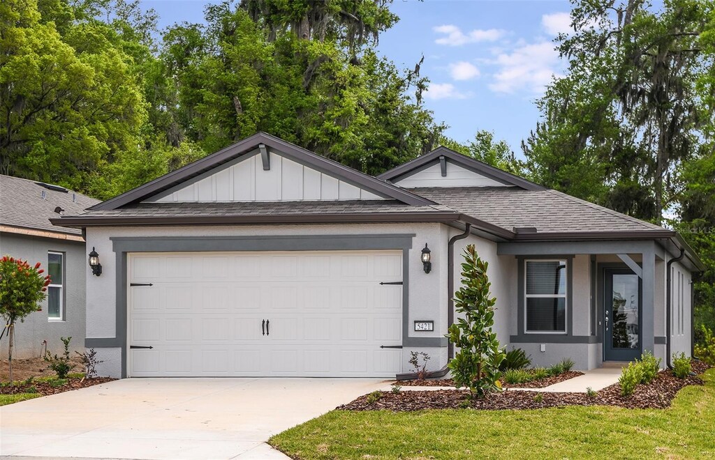 5421 SW 82nd Ter, Ocala, FL 34481 - ranch-style home featuring an attached garage, roof with shingles, concrete driveway, and stucco siding