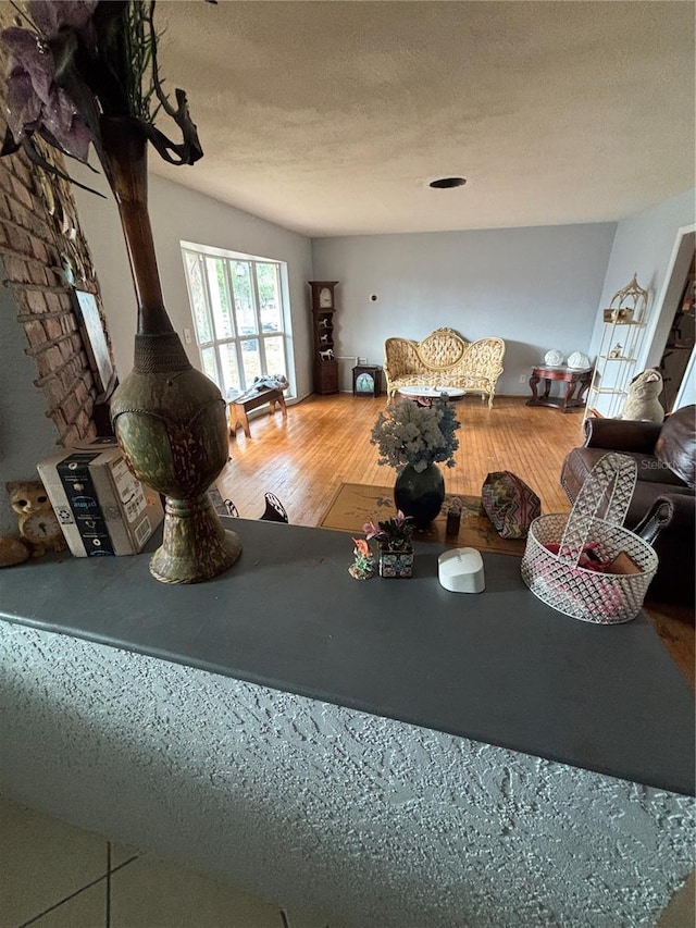 living room featuring hardwood / wood-style floors, a textured ceiling, and a wood stove