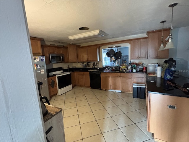 kitchen featuring pendant lighting, sink, light tile patterned floors, stainless steel appliances, and a textured ceiling