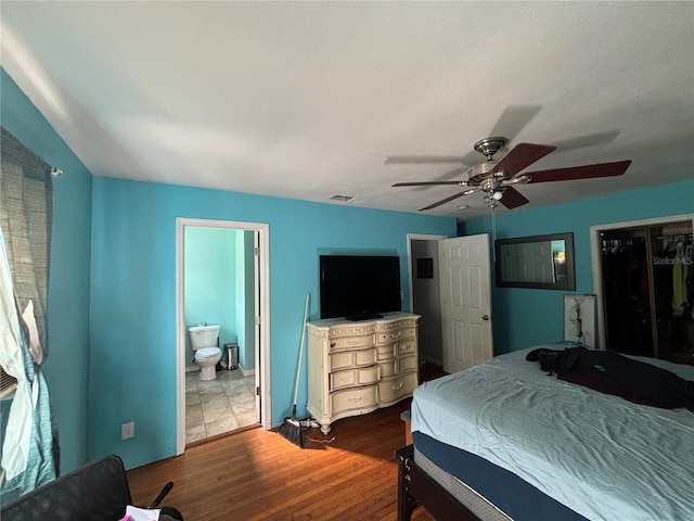 bedroom with ceiling fan, wood-type flooring, ensuite bath, and a closet