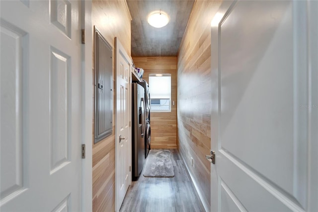 hallway with hardwood / wood-style flooring and wooden walls