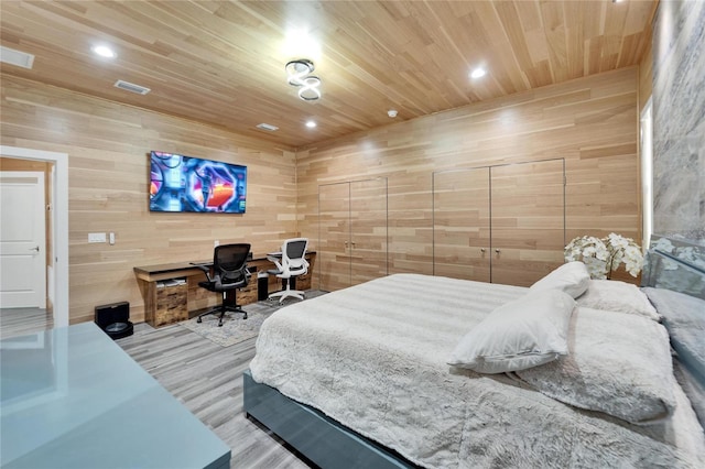 bedroom with wooden walls, hardwood / wood-style floors, and wood ceiling