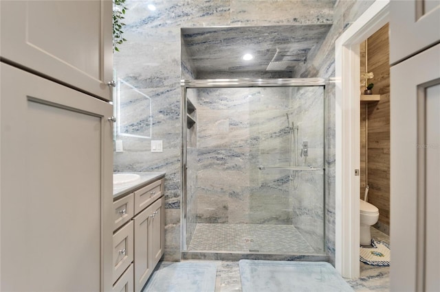 bathroom featuring vanity, walk in shower, and toilet