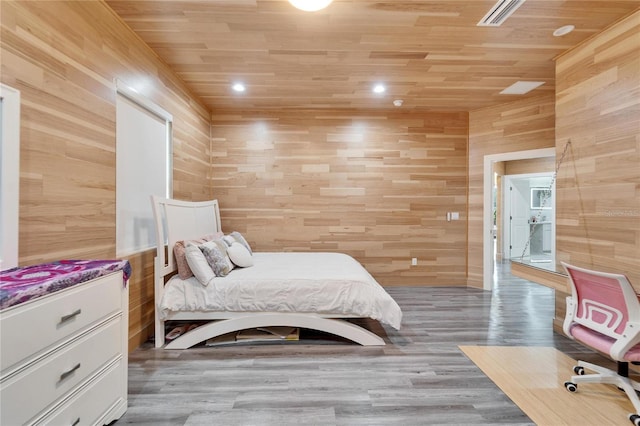 bedroom with wood-type flooring, wooden ceiling, and wood walls