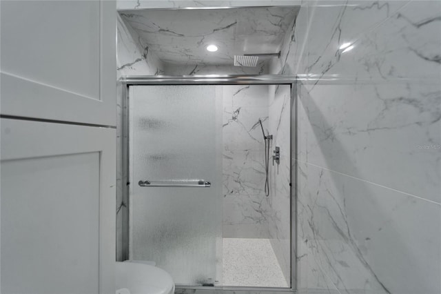 bathroom with an enclosed shower and toilet