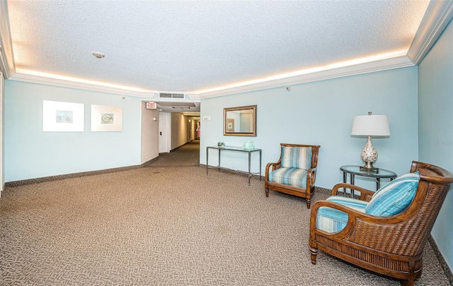 living area featuring ornamental molding, a textured ceiling, and carpet