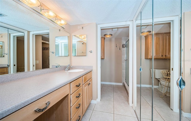 bathroom featuring tile patterned floors, vanity, a shower with shower door, and a textured ceiling