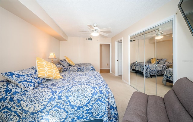 carpeted bedroom with ceiling fan and a textured ceiling