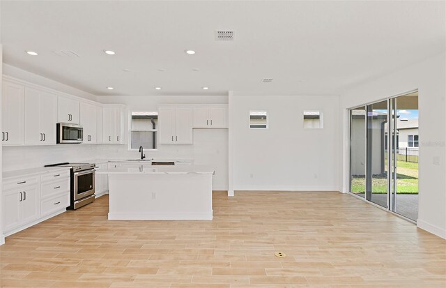 kitchen with visible vents, light countertops, white cabinetry, a sink, and stainless steel appliances