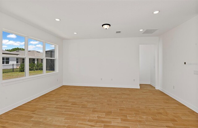 spare room with light wood-type flooring, recessed lighting, baseboards, and visible vents