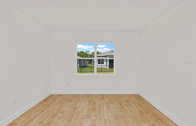 empty room with baseboards and light wood finished floors