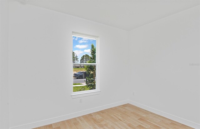 empty room with baseboards and light wood-type flooring