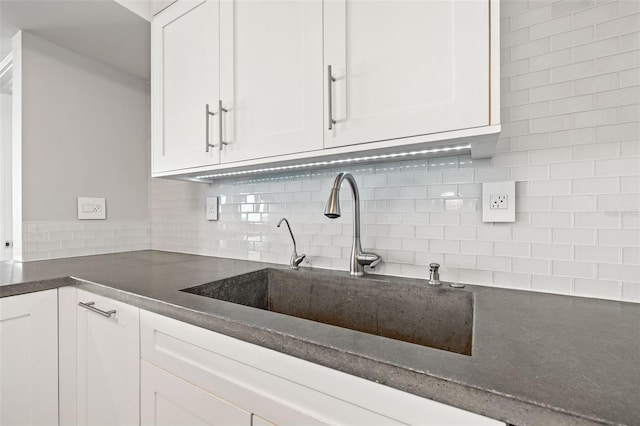 kitchen with white cabinetry, sink, and tasteful backsplash