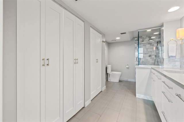 bathroom with vanity, toilet, and a shower with door