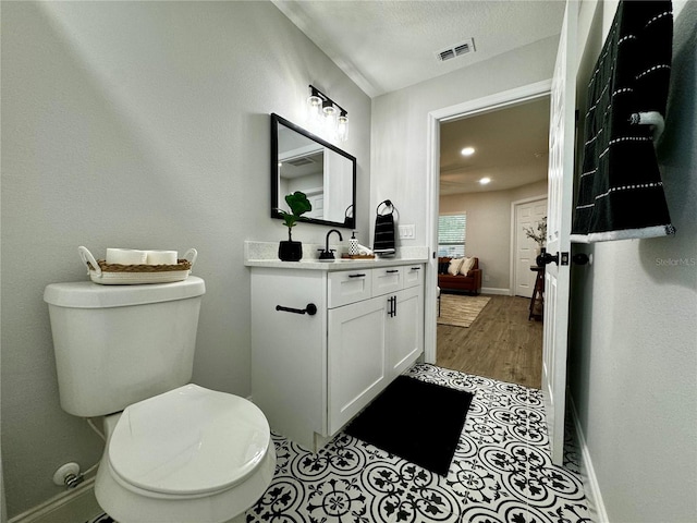 bathroom featuring vanity, a textured ceiling, and toilet