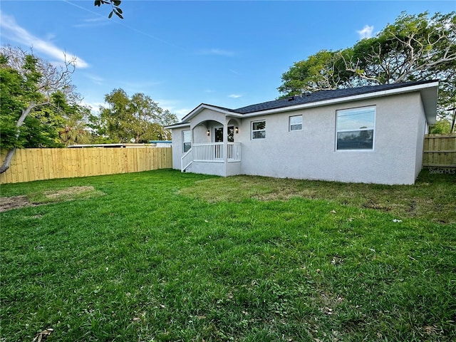 back of house with a lawn