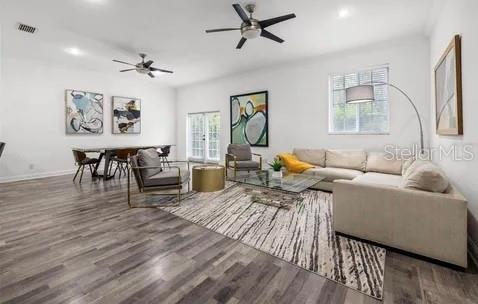 living room featuring ceiling fan and dark hardwood / wood-style flooring