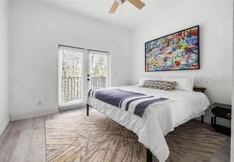 bedroom featuring access to exterior, hardwood / wood-style floors, french doors, and ceiling fan