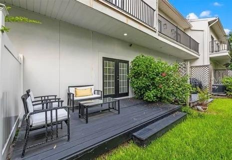 wooden terrace with french doors and a lawn