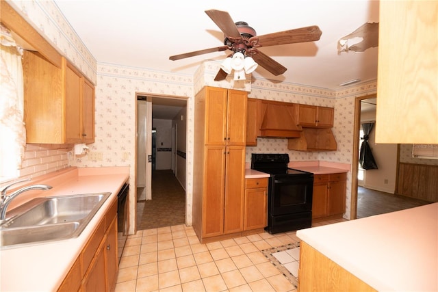 kitchen featuring wallpapered walls, custom exhaust hood, light countertops, black appliances, and a sink