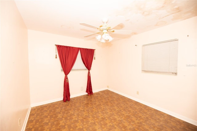 spare room with baseboards and a ceiling fan