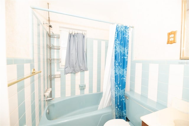 bathroom featuring vanity, tile walls, toilet, and shower / bath combo with shower curtain