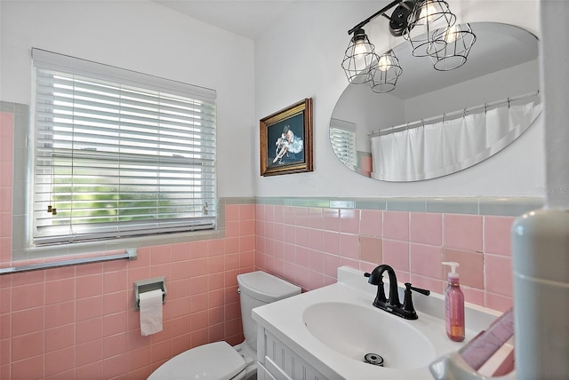 bathroom with vanity, toilet, and tile walls