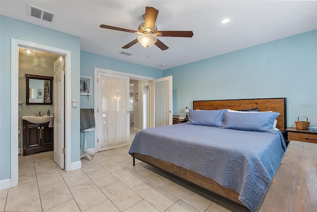 tiled bedroom featuring sink, ceiling fan, and ensuite bathroom