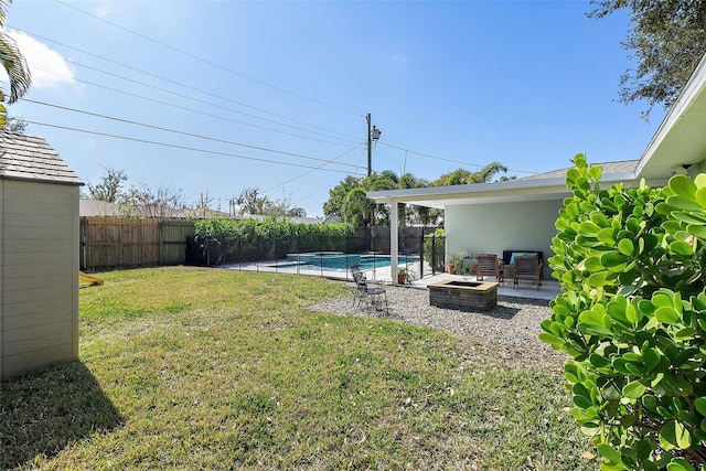 view of yard featuring a fenced in pool, a fire pit, and a patio area