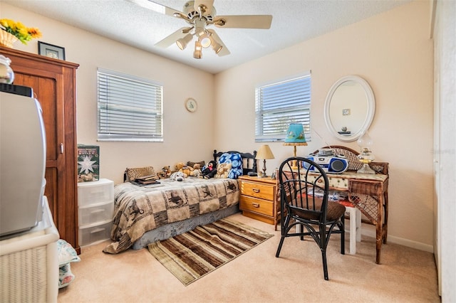 bedroom with ceiling fan, carpet floors, and a textured ceiling