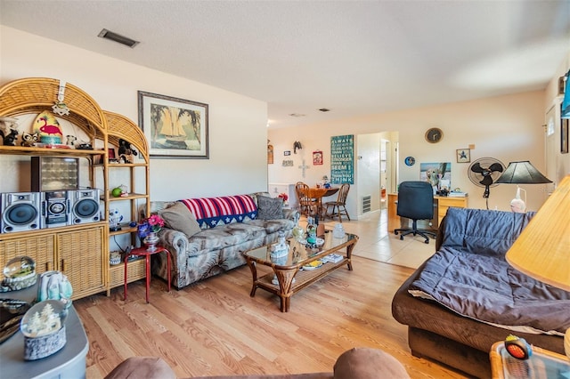 living room with a textured ceiling and light wood-type flooring