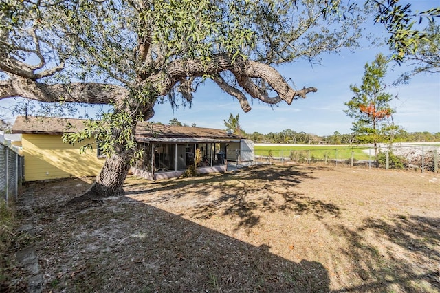 view of yard featuring a sunroom and a rural view