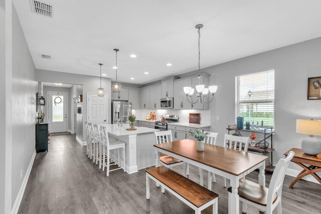 dining space featuring light hardwood / wood-style floors and a chandelier